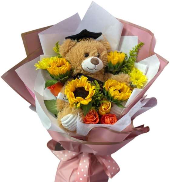 Bouquet with a teddy bear and yellow flowers wrapped in pink paper