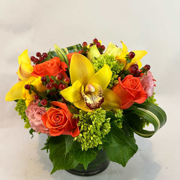 Yellow orchids and orange roses in a low black vase