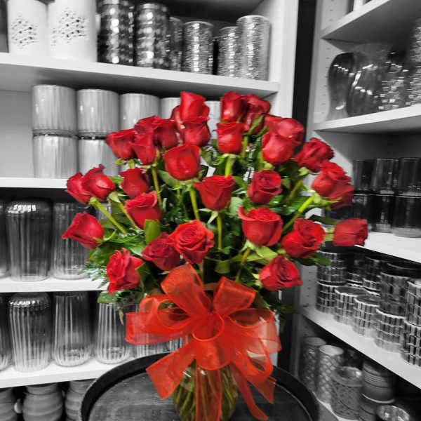 Bouquet of red roses in a glass vase with a red ribbon