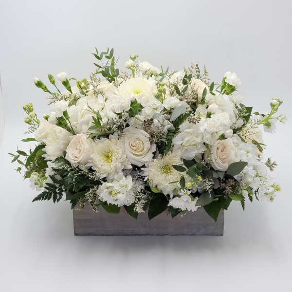 White floral arrangement in a rectangular gray container