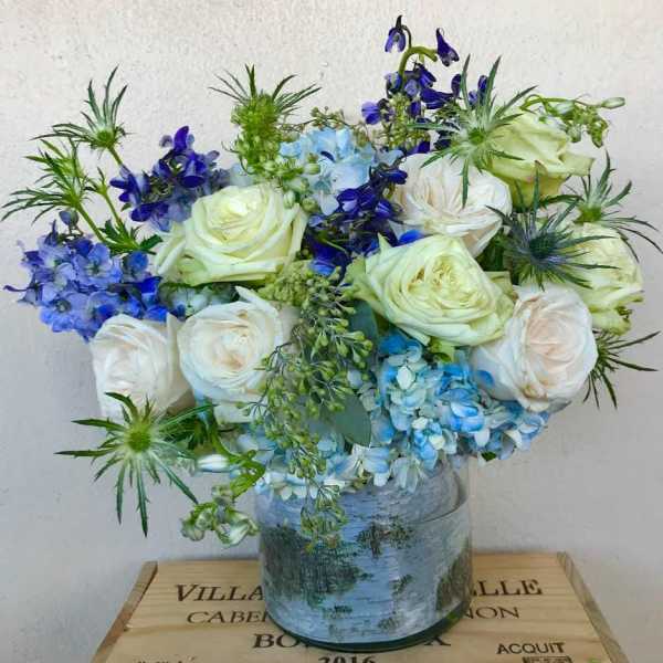 Blue and white floral arrangement in a glass vase