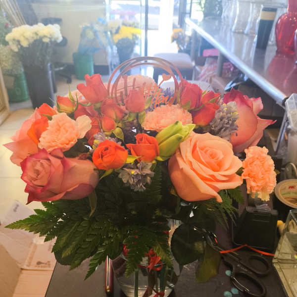 Peach and coral rose bouquet in a clear vase
