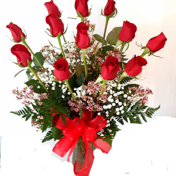 Bouquet of red roses with baby's breath in a glass vase