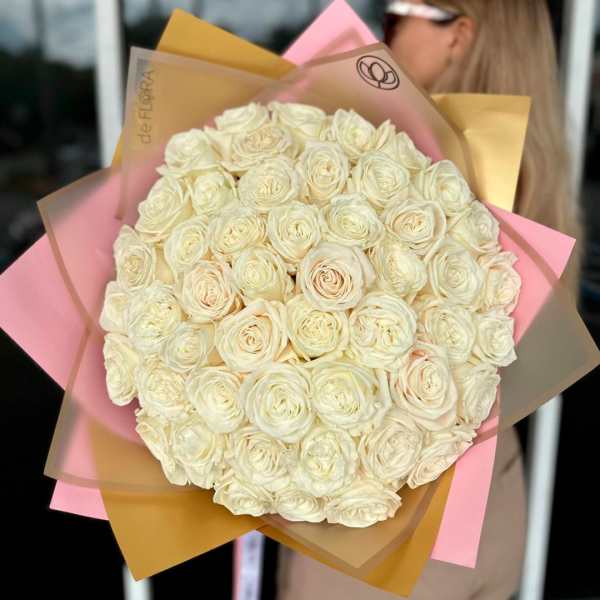 Large bouquet of cream roses wrapped in pink and tan paper