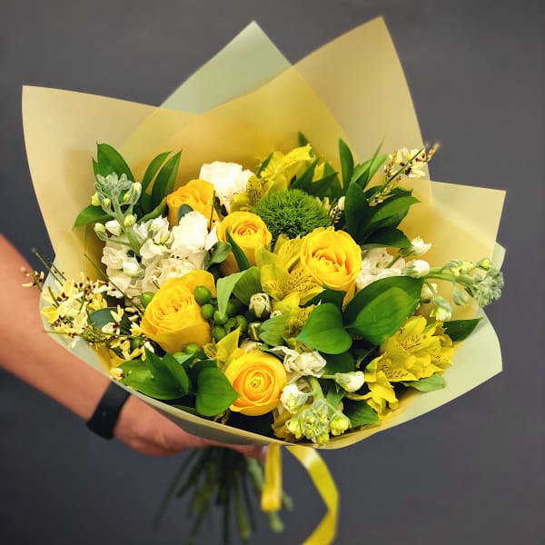 Yellow roses and white flowers in pale wrapping paper
