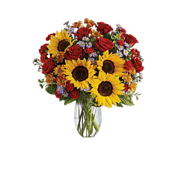 Bouquet of sunflowers, red roses, and small purple flowers in a glass vase