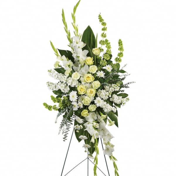 Tall white and pale yellow funeral spray on a stand