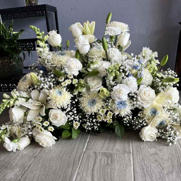 Large white floral arrangement with roses, lilies, and chrysanthemums