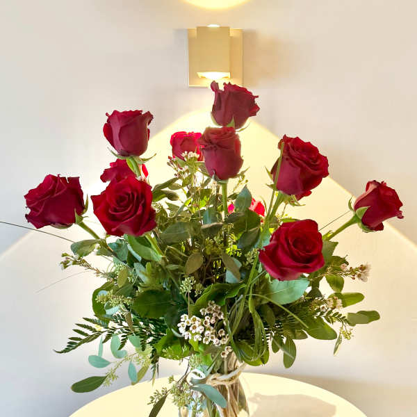 Tall bouquet of red roses in a clear glass vase
