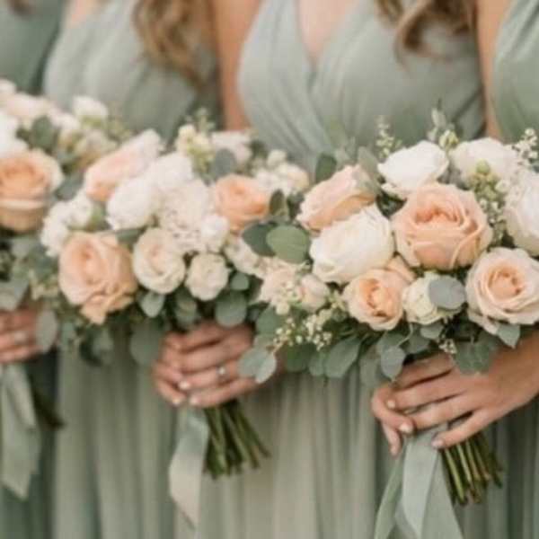 Bridesmaids holding blush and white rose bouquets