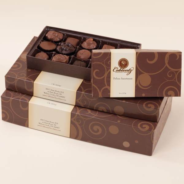 Stacked boxes of assorted chocolates with one open tray