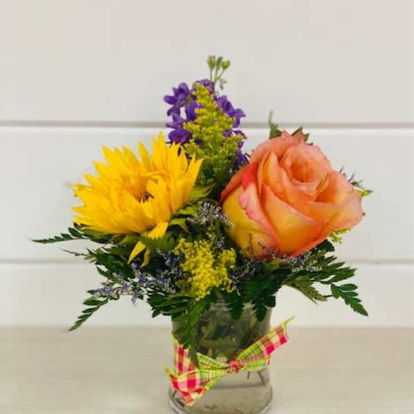 Small bouquet with a yellow sunflower and peach rose in a glass vase