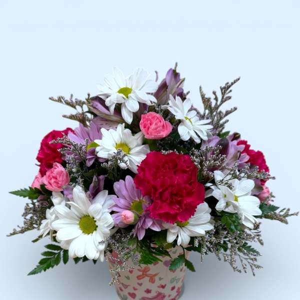 Bouquet of daisies, carnations, and purple flowers in a patterned pot
