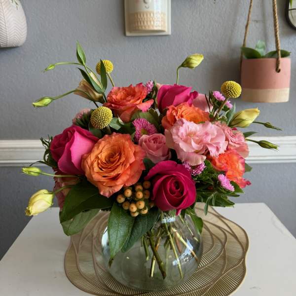Mixed pink and orange roses in a glass vase