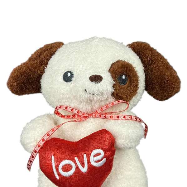 Plush puppy holding a red heart with the word love