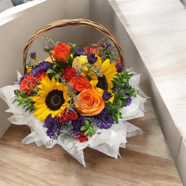 Basket bouquet of sunflowers, roses, and purple flowers