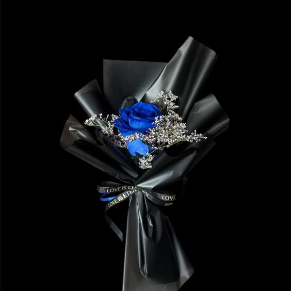 Blue rose bouquet wrapped in black paper with a ribbon