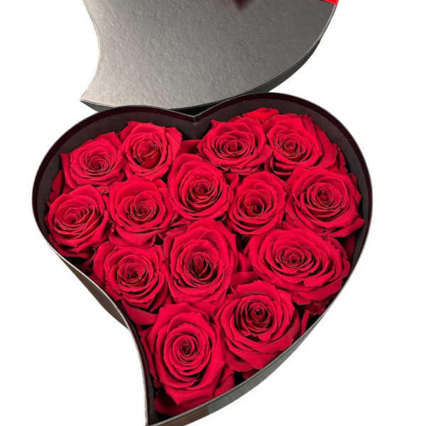 Heart-shaped box filled with red roses and tied with a red ribbon