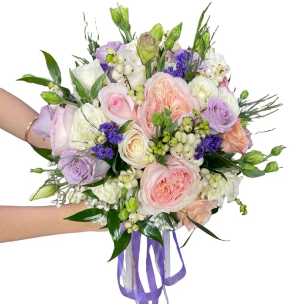 Hand-tied bouquet of pastel roses and purple flowers with ribbon tails