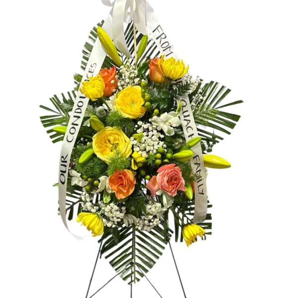 Standing floral wreath with yellow and orange roses and lilies on a white easel