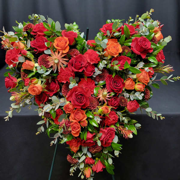 Heart-shaped floral spray with red and orange roses