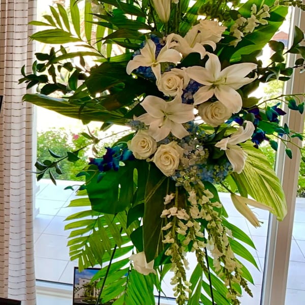 Tall white floral standing arrangement with lilies and roses