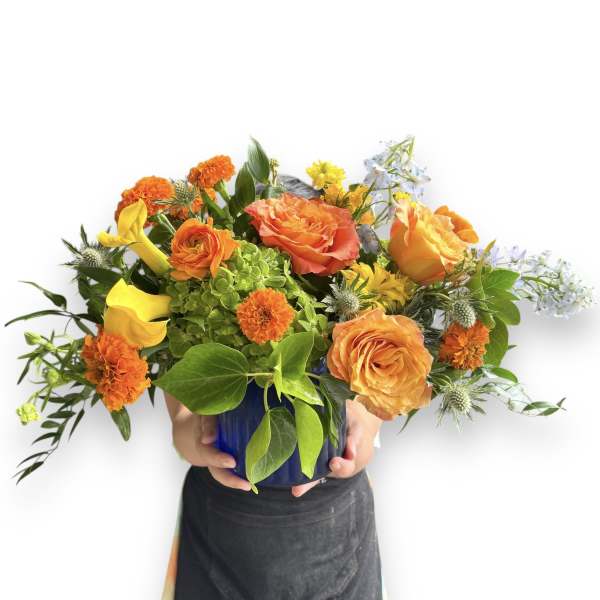 Orange and yellow mixed bouquet in a blue vase