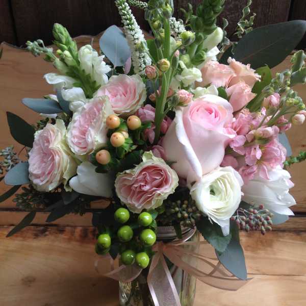 Pink and white bouquet in a glass vase with ribbon