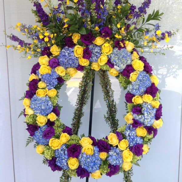 Large floral wreath with yellow and purple roses and blue hydrangeas