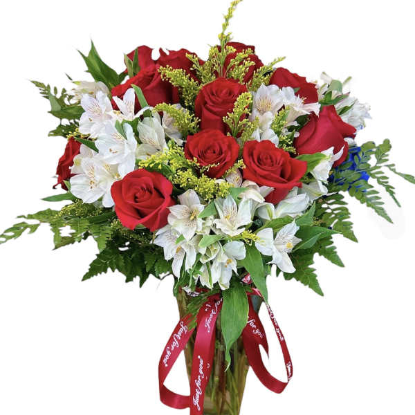 Bouquet of red roses and white alstroemeria in a glass vase