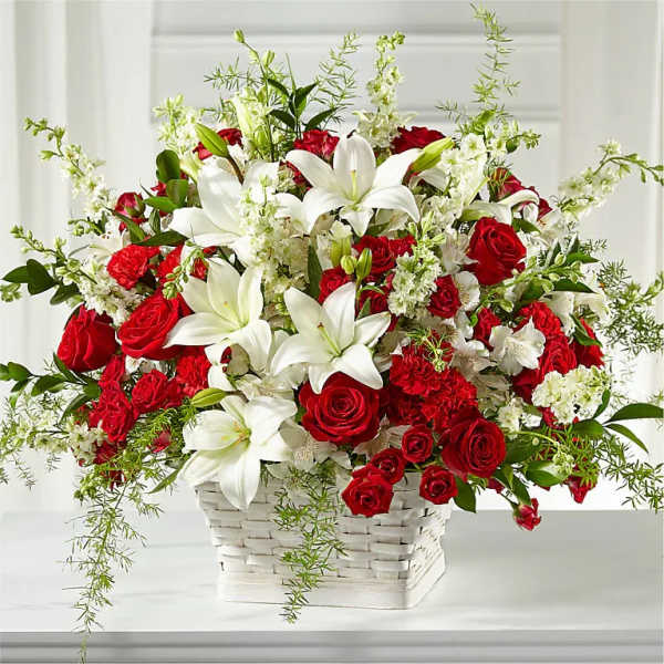 Red roses and white lilies in a white basket
