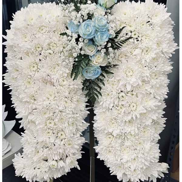 White chrysanthemum funeral spray with pale blue roses