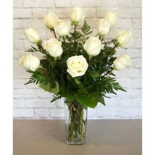 White roses arranged in a clear glass vase