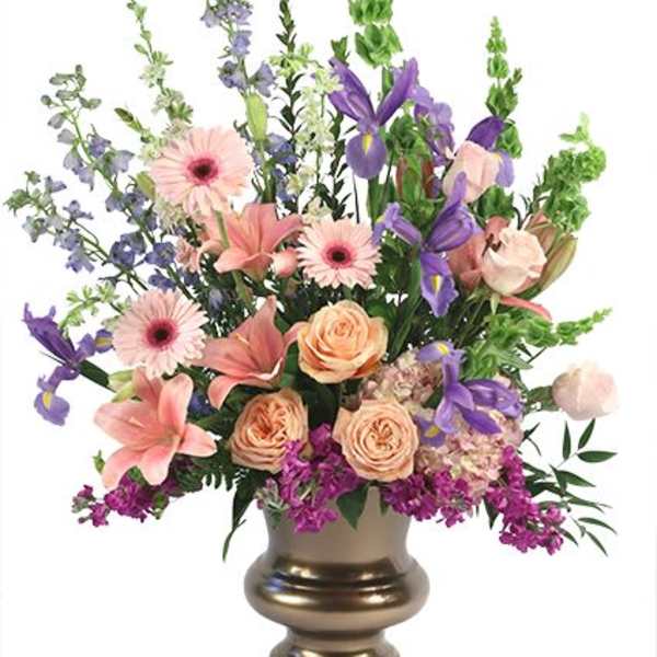 Mixed pink, purple, and peach flowers in a gold vase