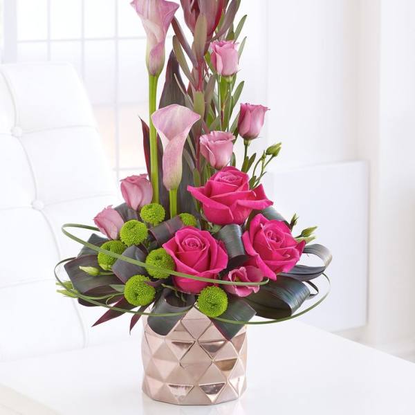 Pink roses and calla lilies in a geometric vase