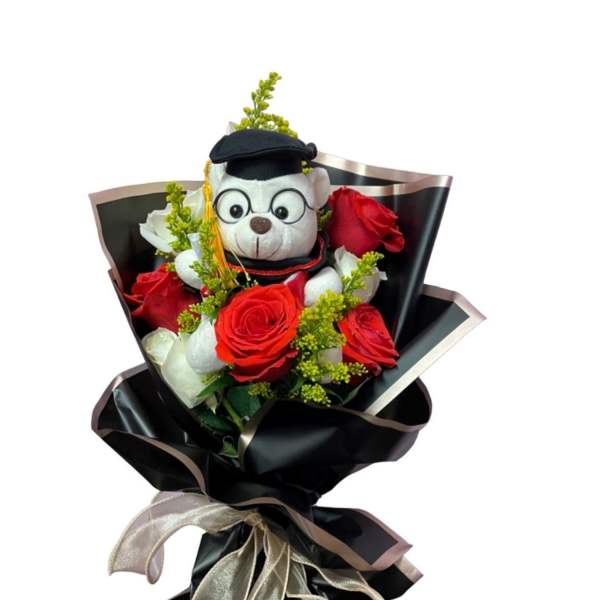 Bouquet of red roses with a teddy bear in graduation cap