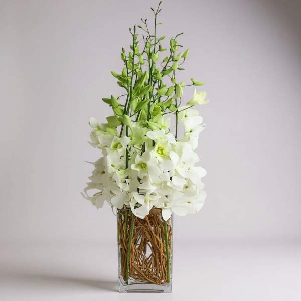 White orchid arrangement in a clear rectangular vase