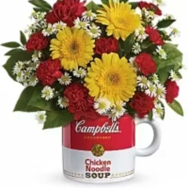 Bouquet of red and yellow flowers arranged in a soup mug