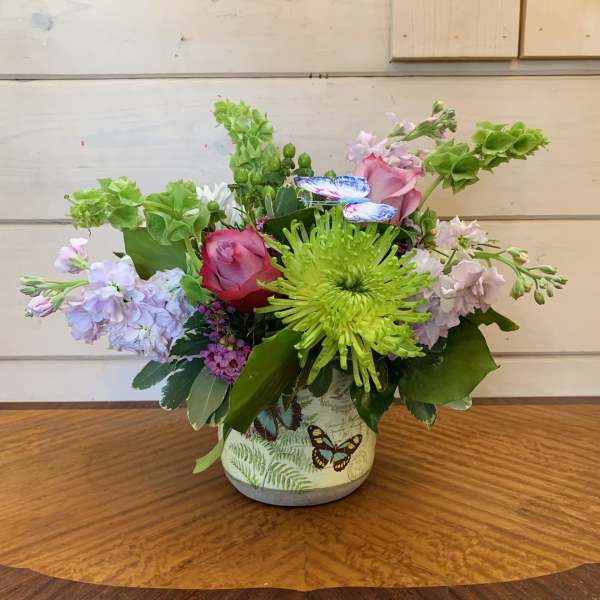 Mixed bouquet in a butterfly-decorated ceramic pot