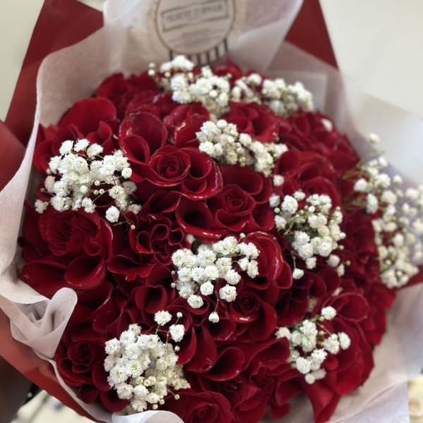 Bouquet of red roses with white baby's breath in red and white wrap