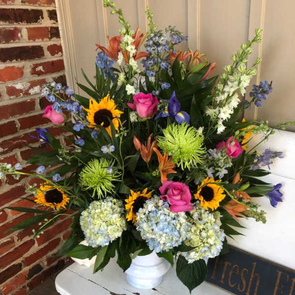Colorful mixed flower arrangement in a white vase