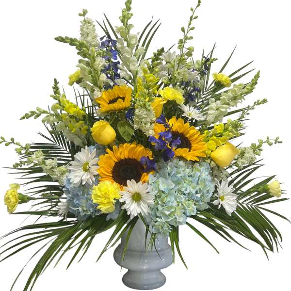 Mixed bouquet of sunflowers, hydrangeas, and daisies in a gray vase