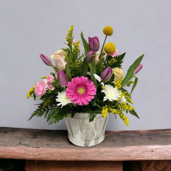 Mixed bouquet in a white wooden pot with pink, purple, yellow, and white flowers