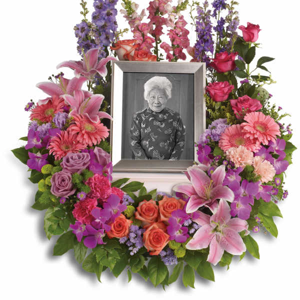 Colorful floral wreath around a framed black-and-white portrait