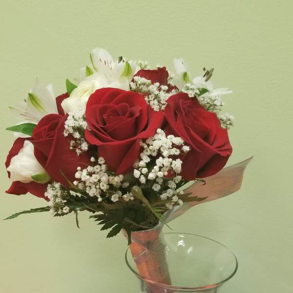 Red roses and white lilies in a clear glass vase