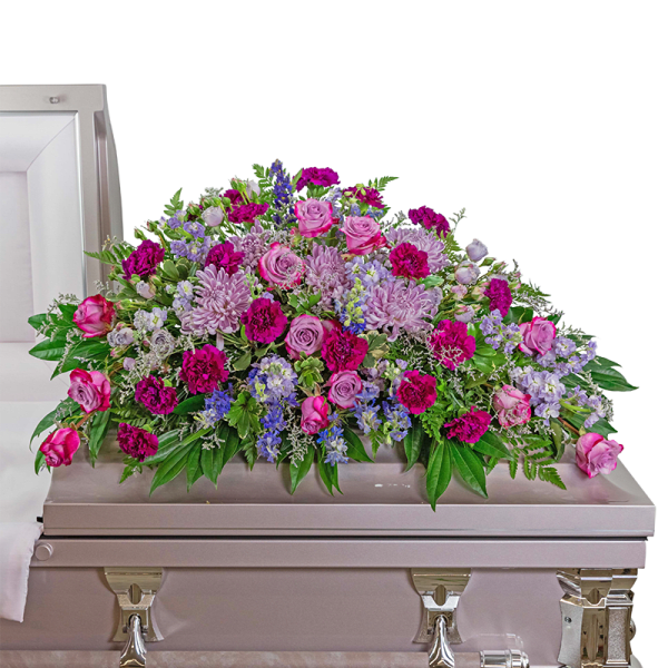 Pink and lavender flower casket spray arranged on a light pink casket
