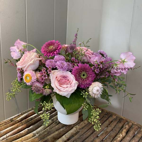 Pink and purple mixed bouquet in a white vase