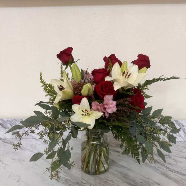 Bouquet of red roses and white lilies in a glass vase