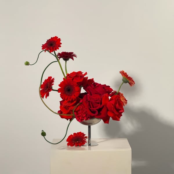 Red roses and gerbera daisies in a glass vase