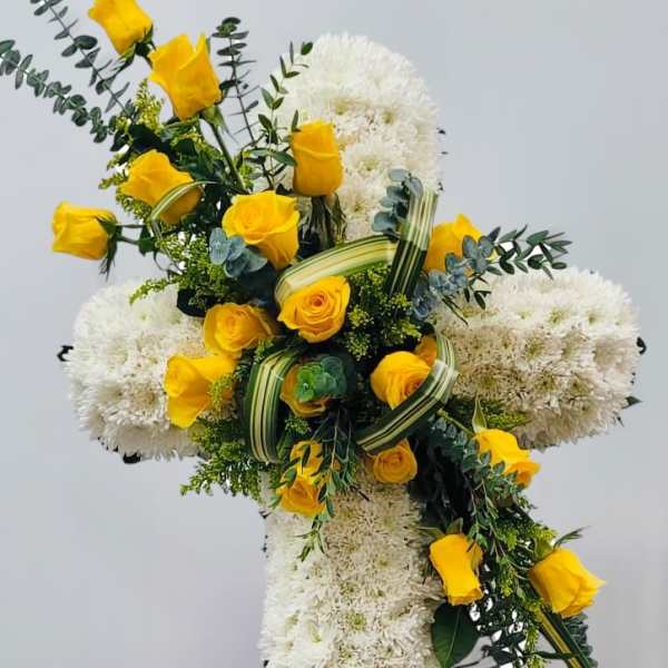 Cross-shaped floral tribute with yellow roses and white chrysanthemums